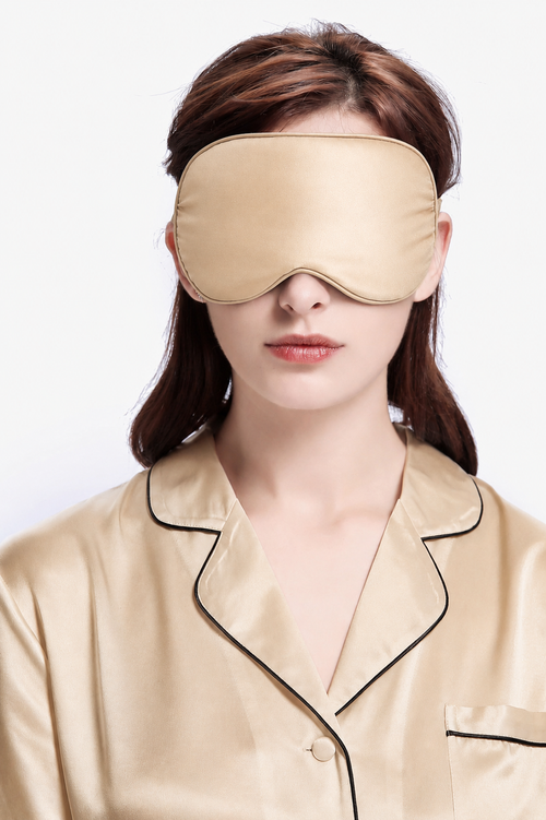 Sand Beige silk sleep mask worn over the eyes with a contoured curve and side ties