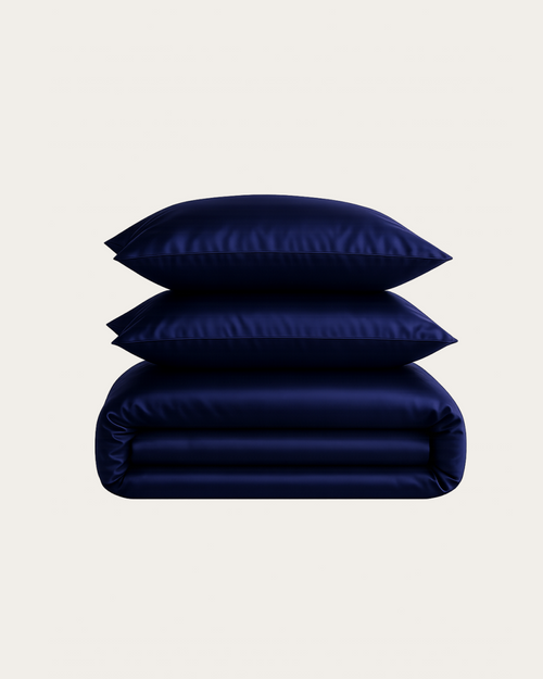 Navy Blue silk bedding set with two folded pillow shams and a folded duvet cover